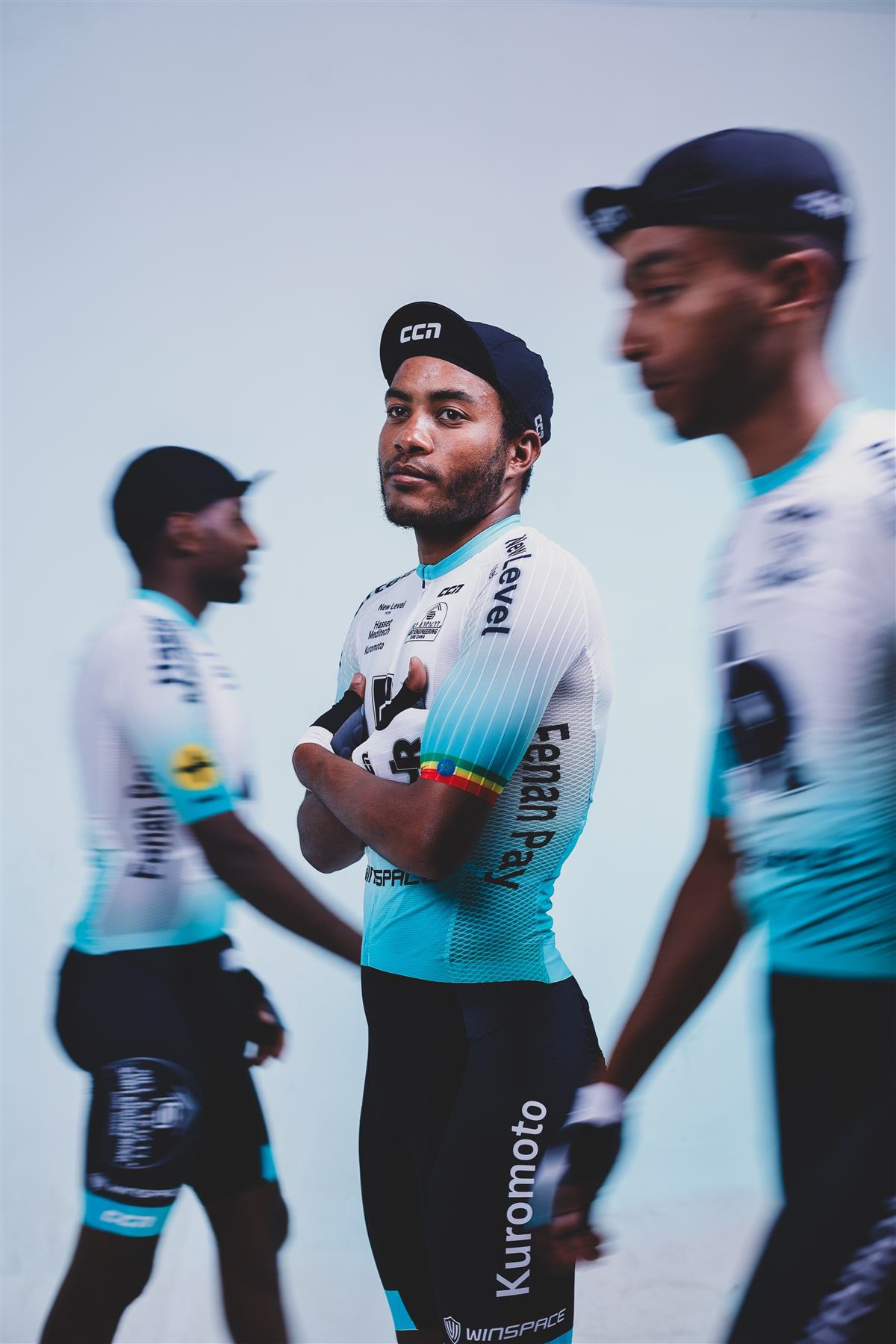 A rider looking at the camera as teammates blur past